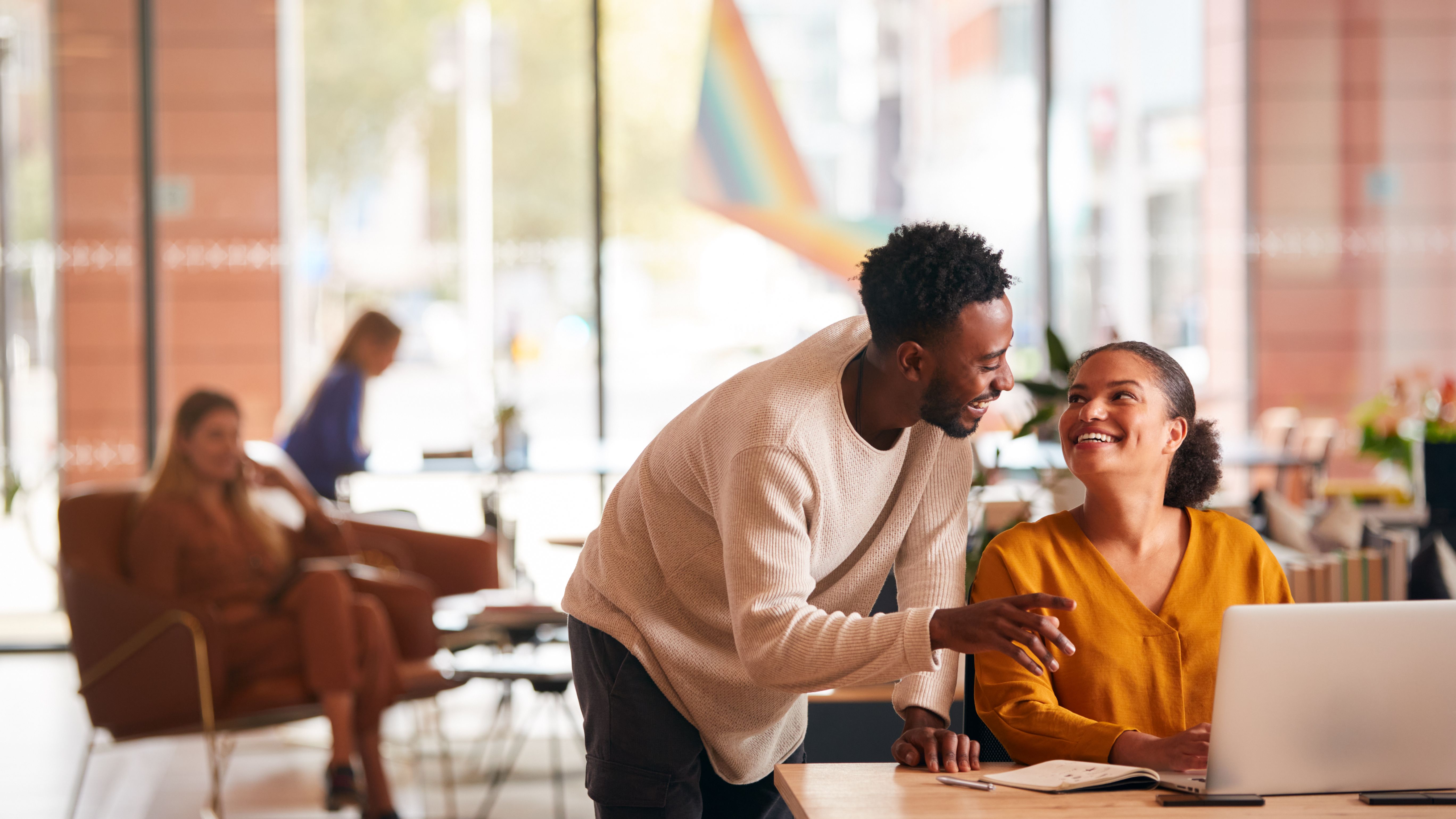 Happy Employees At An Office With A Pride Flag Flying Outside